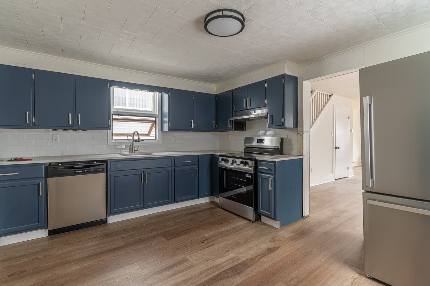 Renovated kitchen at 119 Pine Street in Nanticoke, Pennsylvania, with blue cabinetry and stainless-steel appliances